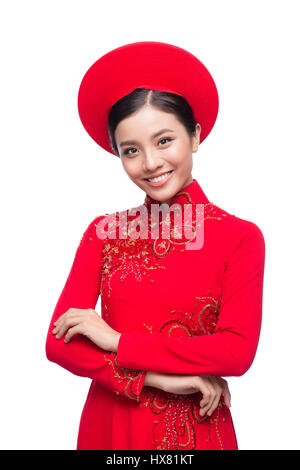 Charmante épouse vietnamienne en ao Dai rouge robe traditionnelle avec chapeau. Banque D'Images