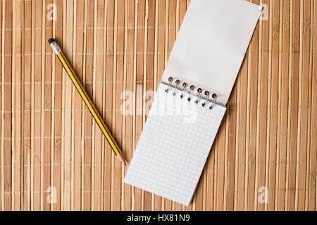 Le bloc-notes et crayon sur une table de bambou Banque D'Images