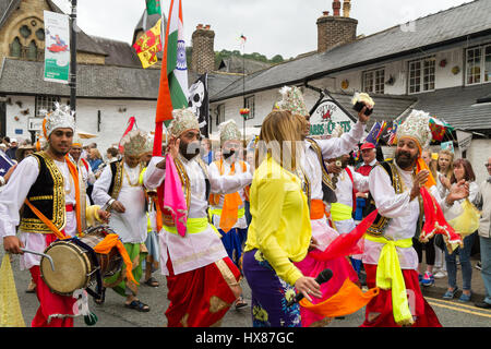 La population locale les visiteurs et les artistes interprètes ou exécutants sikh qui prennent part à la street parade à Llangollen au début de l'Eisteddfod international annuel Banque D'Images