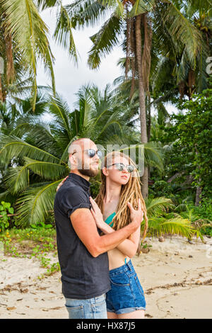 Jeune couple standing on beach et à la recherche en mer Banque D'Images