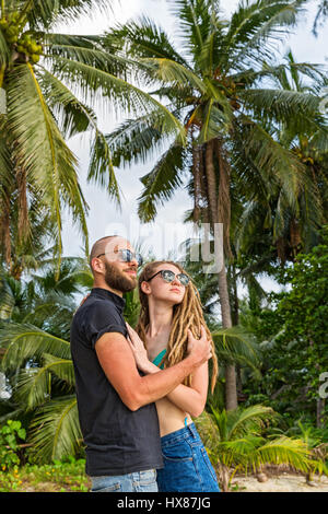 Jeune couple standing on beach et à la recherche en mer Banque D'Images