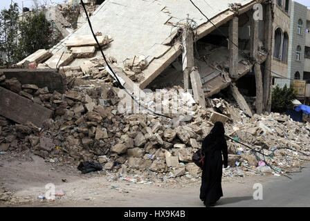 (170325) -- SANAA, le 25 mars 2017 (Xinhua) -- une femme passe devant les décombres d'une maison détruite dans le district de frappes aériennes à l'aéroport de Sanaa, capitale du Yémen, un jour avant le deuxième anniversaire de l'intervention militaire au Yémen, le 25 mars 2017. Que la guerre se poursuit au Yémen pour deux ans depuis une intervention militaire dirigée par l'Arabie saoudite, les observateurs ont commencé à faire valoir que l'objectif de l'intervention militaire est devenu difficile, ce qui se traduit par aucune victoire militaire encore. Selon les rapports des médias citant le porte-parole de la coalition dirigée par les Saoudiens, Ahmed Al-Asiri, la coalition a effectué 90, 0 Banque D'Images