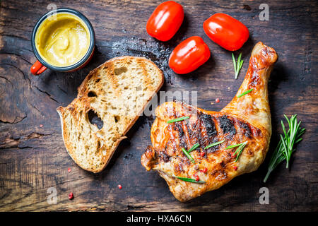 Cuisse de poulet grillé avec du pain grillé et tomates cerises Banque D'Images