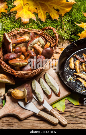 La préparation des champignons sauvages à la friture sur table en bois ancien Banque D'Images