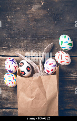 Lapin de Pâques dans un sac en papier sur les anciennes cartes Banque D'Images
