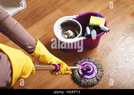 Les mains dans les gants en caoutchouc laver le plancher avec chiffon. Concept servisce de nettoyage Banque D'Images