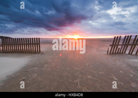 Vent qui souffle du sable sur la plage de Tarifa en Espagne au coucher du soleil Banque D'Images