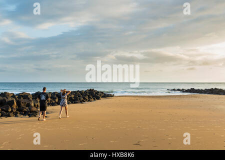 Couple en train de marcher le long de plage de Bargara, Bundaberg, Queensland, Australie Banque D'Images