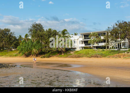 Couple en train de marcher le long de la plage à l'aube, Bargara, Bundaberg, Queensland, Australie Banque D'Images