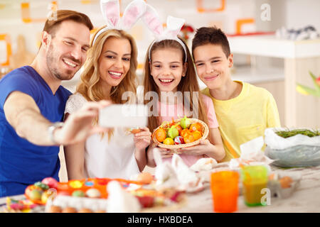 Happy Family faire avec selfies panier d'oeufs de Pâques colorés Banque D'Images