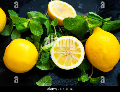 Citrons frais et menthe feuilles d'herbe sur fond de bois Banque D'Images