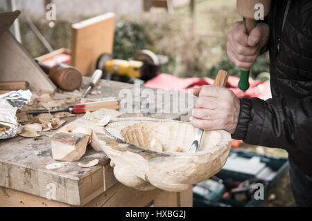 Carpenter sculpte un masque de carnaval en bois. Banque D'Images