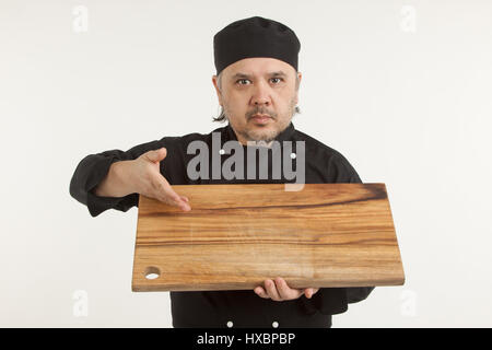 Asian Senior Chef holding planche à découper en bois contre fond blanc Banque D'Images