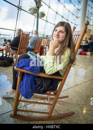 Une fille est assise sur une chaise à bascule dans le marché du Pacifique Central Terminal de l'Aéroport International de Seattle-Tacoma (Sea-Tac Airport). Banque D'Images