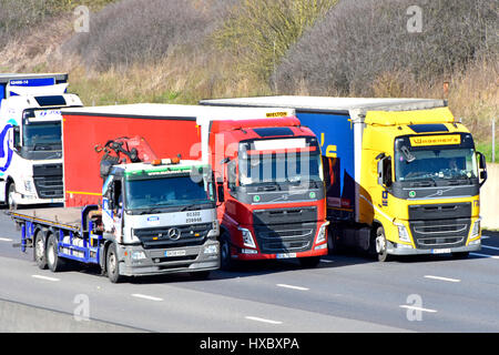 Autoroute M25 UK camion trafic routier la conduite en trois voies de dépassement des deux camions continental dans l'état occupé d'autoroute à quatre voies de circulation l'article Banque D'Images