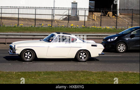 Un enregistrement de 1972 K vintage Volvo P1800 voiture de sport comme entraîné par Roger Moore se déplaçant le long de la Kingsway West à deux voies dans Dundee, Royaume-Uni Banque D'Images