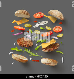 Vue de dessus du hamburger ou un sandwich au fromage, tomate, boeuf, etc. représentés à l'arrière-plan gris séparément. Ingrédients du hamburger concept. Banque D'Images