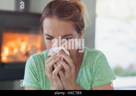 Femme avec des tissus blowing nose Banque D'Images