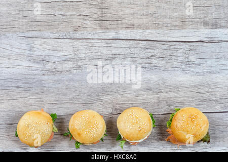Burger au saumon fumé feuilleté en ligne avec vue sur la vieille planche de bois Banque D'Images