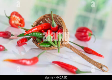 Red Hot Chili Peppers dans un panier en osier sur un arrière-plan de cuisine Banque D'Images