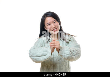 Les jeunes Chinois sincère sourire femme en blanc pull offrant de nouveaux messages d'année de l'observateur faisant des gestes avec ses mains, Close up isolated on white Banque D'Images