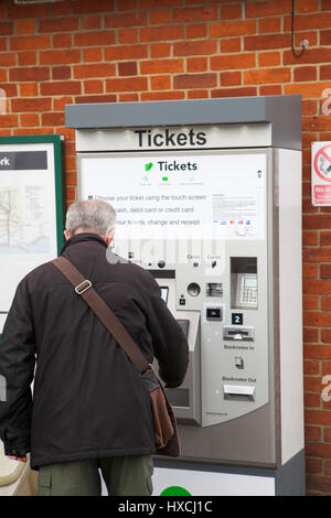 L'homme de la sélection d'un billet à un distributeur automatique de billets de train à l'extérieur de la gare de Rye. Rye East Sussex Banque D'Images