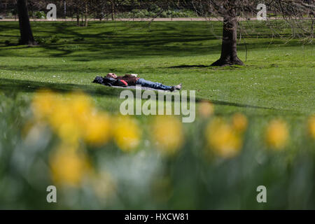 Londres, Royaume-Uni. 26 mars 2017. Un homme se détend sur l'herbe à St James's Park à Londres au cours du printemps ensoleillé. Credit : Vickie Flores/Alamy Live News Banque D'Images