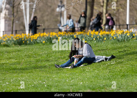 Londres, Royaume-Uni. 26 mars 2017. Un homme se détend sur l'herbe à St James's Park à Londres au cours du printemps ensoleillé. Credit : Vickie Flores/Alamy Live News Banque D'Images