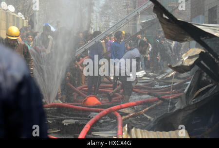 Srinagar, Cachemire sous administration indienne. 27 mars 2017 incendie et d'offres. sections locales ont été à l'œuvre pour éteindre les flammes qui ont éclaté à partir de l'une des maisons d'en face le sanctuaire de Faqeer Mohammad Abdullah Sheikh à Bagh Chinar localité sur les rives d'un cours d'eau près de la zone de Srinagar Dalgate Crédit : Sofi Suhail/Alamy Live News Banque D'Images
