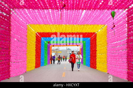 Tangshan, Province de Hebei en Chine. Mar 27, 2017. Les touristes à pied sur une route décoré de rosettes colorées à un festival de cerf-volant et moulinet à Tangshan, Province de Hebei en Chine du nord, le 27 mars 2017. Credit : Mu Yu/Xinhua/Alamy Live News Banque D'Images