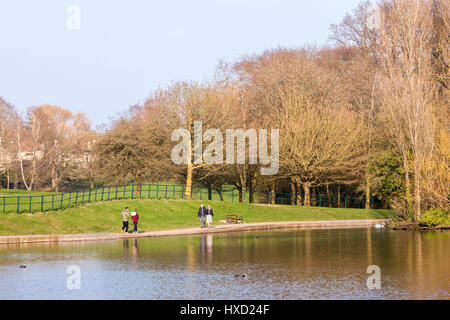 Abington, Northampton, Royaume-Uni. Mar 27, 2017. Météo britannique. Après un matin nuageux gris et froid le soleil est apparu en fin d'après-midi, les gens ont été rapidement dans le parc pour profiter de la chaleur du soleil à côté de la volaille de l'eau. Credit : Keith J Smith./Alamy Live News Banque D'Images