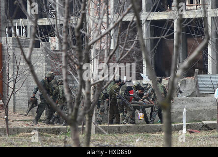 Srinagar, au Cachemire. Mar 28, 2017. Troopers de l'armée indienne et les policiers l'évacuation d'un blessé d'un soldat de l'armée de gunfight dans Durbugh site village de Chadoora Budgam de district, à environ 22 km au sud de Srinagar, capitale d'été de la ville de cachemire, le 28 mars 2017. Au moins trois jeunes ont été tués et 13 autres blessés mardi après que les forces gouvernementales ont tiré sur les manifestants à proximité d'un gunfight site en cachemire agitée, a annoncé la police. Credit : Javed Dar/Xinhua/Alamy Live News Banque D'Images