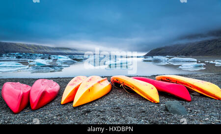 Kayaks sur la rive du lac avec le glacier, l'Islande Banque D'Images