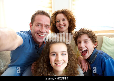 Portrait d'une famille heureuse de prendre une à la maison selfies Banque D'Images