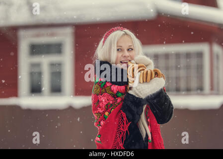 Portrait d'une jeune femme de race blanche dans le style russe sur une forte gelée dans l'hiver un jour de neige. Fille modèle russe en costume traditionnel Banque D'Images