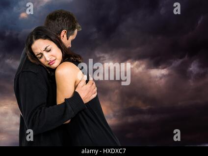 Digital composite de triste couple hugging against the ciel nuageux Banque D'Images