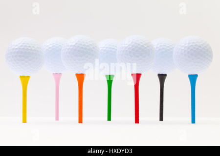 Balles de golf blanc et différents tees sur le fond blanc. Funny golf concept. Banque D'Images