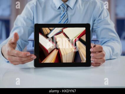 Digital composite de l'homme d'affaires à table avec tablet showing livres permanent contre l'étagère floue avec incrustation bleu Banque D'Images