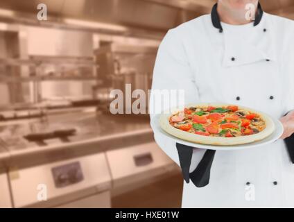 Digital composite de chef avec pizza contre cuisine avec incrustation orange floue Banque D'Images