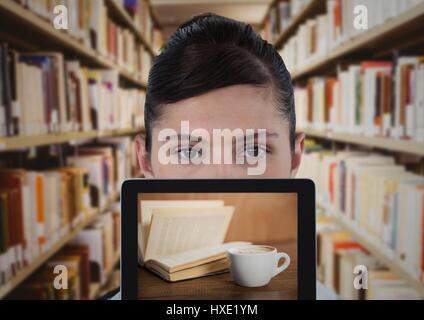 Digital composite of Woman with tablet showing et livre contre café bibliothèque floue Banque D'Images