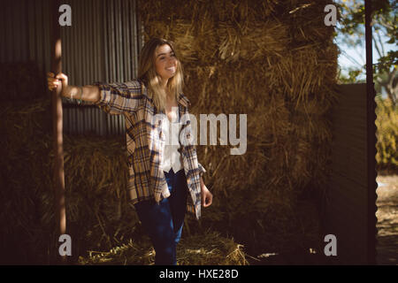 Happy woman standing in stable Banque D'Images