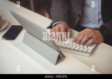Portrait of businessman using digital tablet in coffee shop Banque D'Images