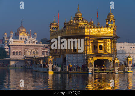 Le Golden Temple à Amritsar, au Pendjab, en Inde, la plus sacrée de l'icône et lieu de culte de la religion Sikh. Coucher du soleil la lumière réfléchie sur le lac. Banque D'Images