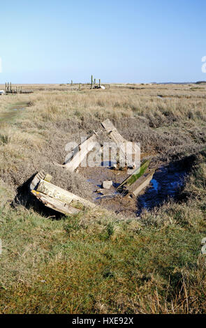 Vestiges d'un vieux bateau de pêche pourri dans des marais salés sur la côte nord de Norfolk à Thornham, Norfolk, Angleterre, Royaume-Uni. Banque D'Images