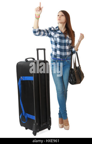 Teen girl de 16 ans, avec un grand sac de voyage noir sur roues. Jeune fille à la recherche de l'horaire dans une station. Une personne, adolescente, femme, vertic Banque D'Images