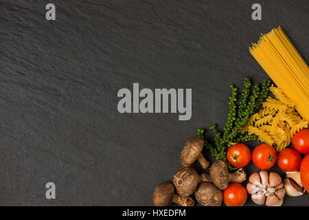 Concept de cuisine italienne. Ingrédients pâtes. Les tomates cerise, les pâtes spaghetti, de romarin et d'épices Banque D'Images