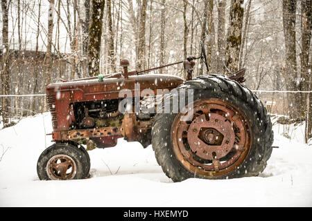 Tracteur antique dans la neige sur une ferme du New Hampshire Banque D'Images