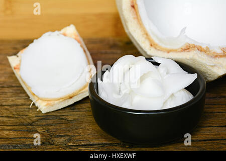 Chair de noix de coco jeunes coupés en bol sur une table en bois noir Banque D'Images