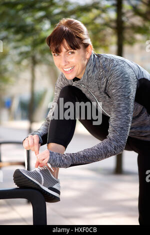 Portrait of a smiling woman sportif extérieur lacet de liage Banque D'Images