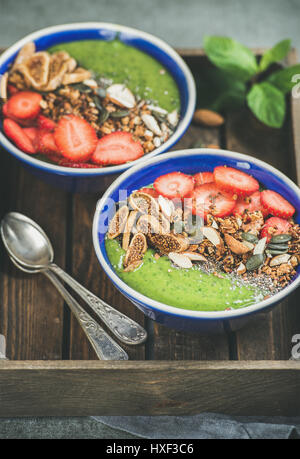 Un petit-déjeuner sain, bols smoothie vert avec céréales, fruits, graines Banque D'Images